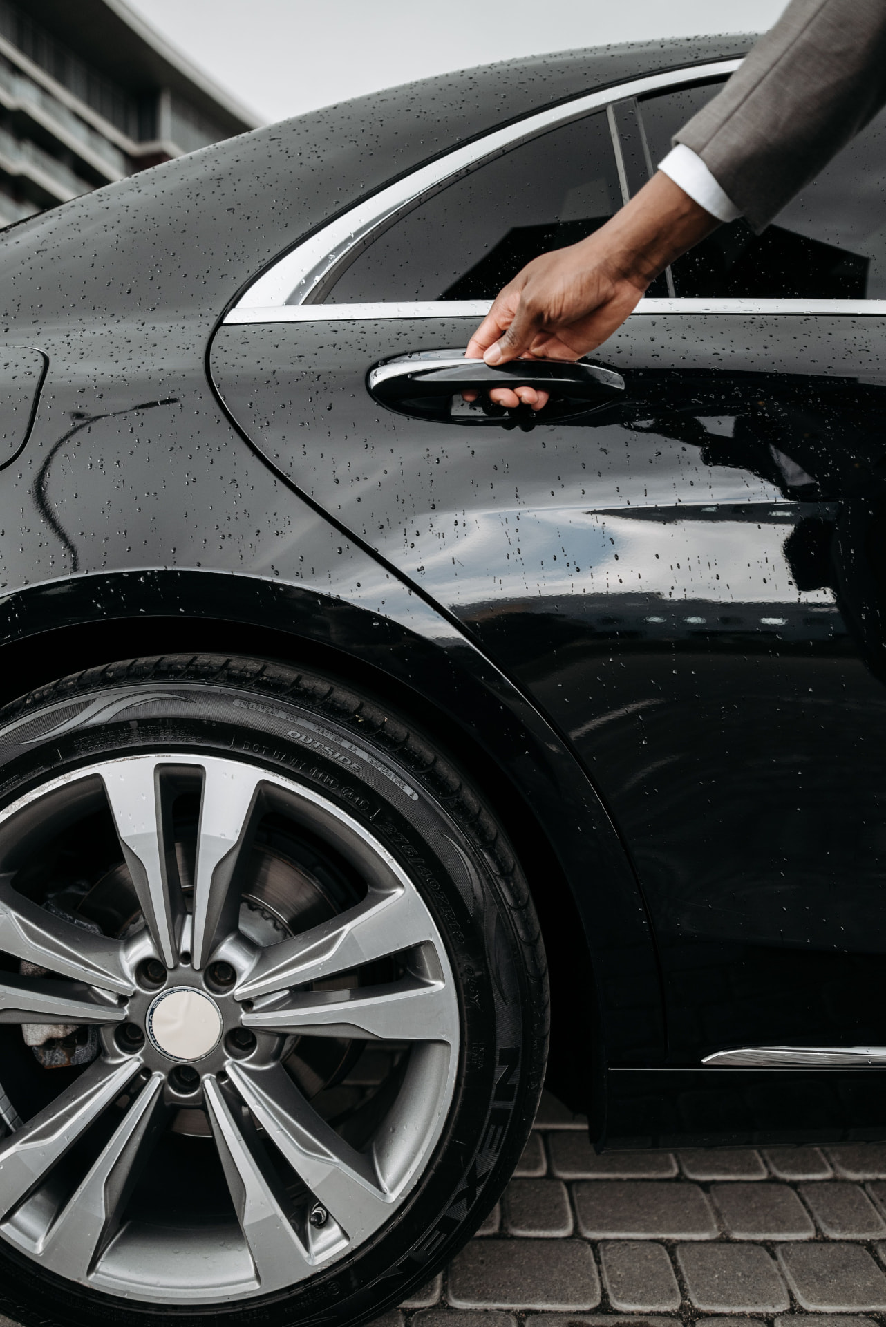 A chauffeur opening the door of a private car